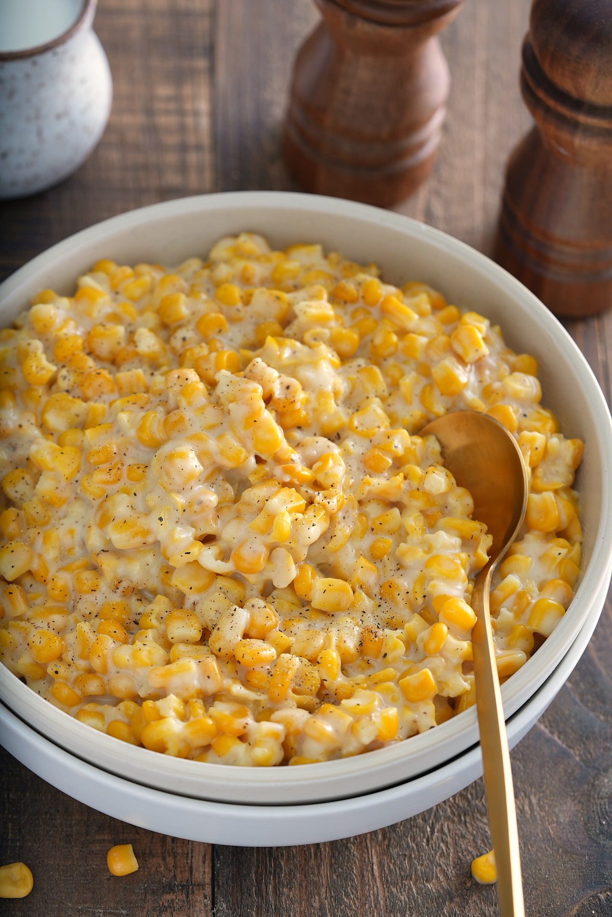 old fashioned cream corn in a plate with salt and pepper to the side
