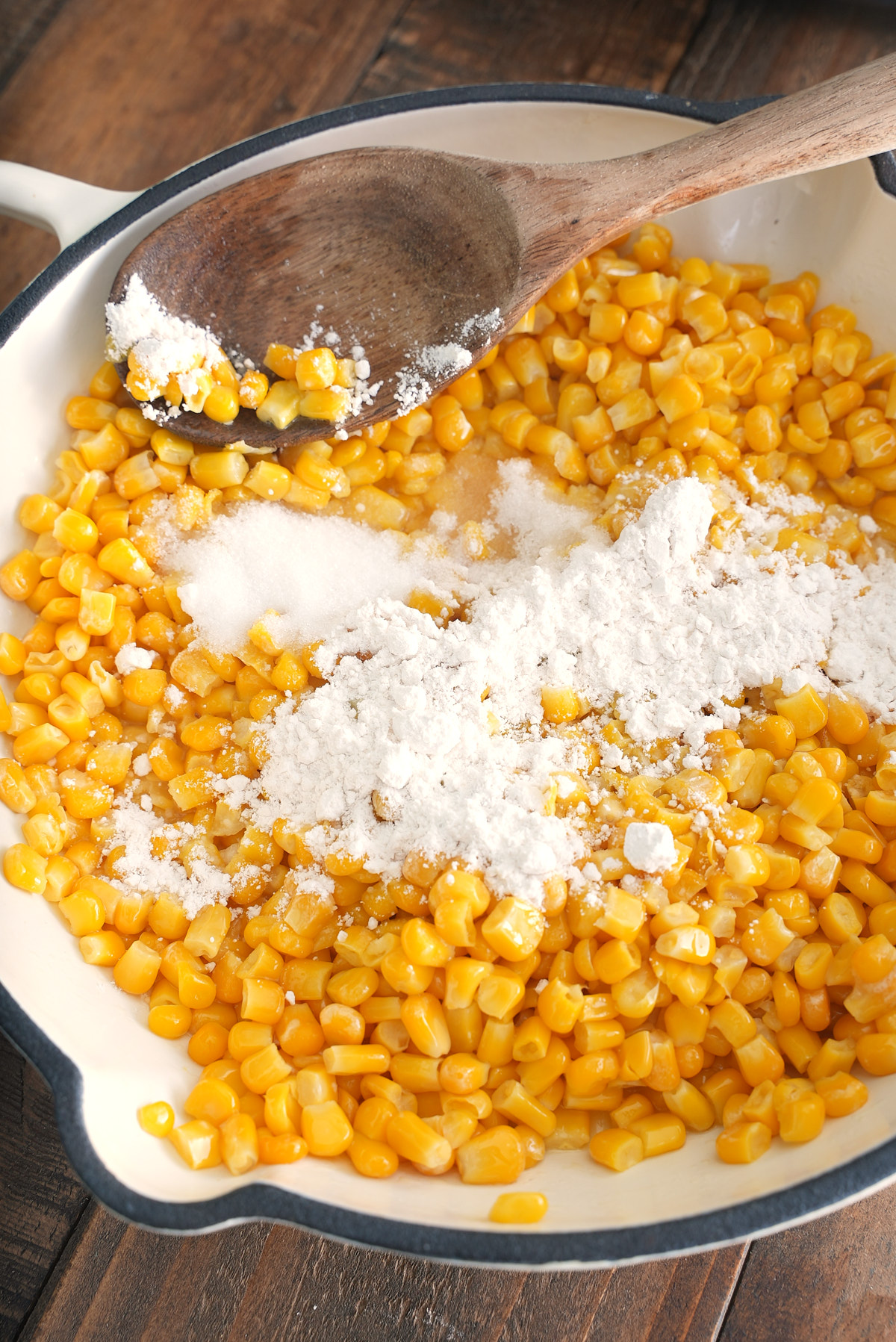 corn in skillet with flour and sugar sprinkled over it