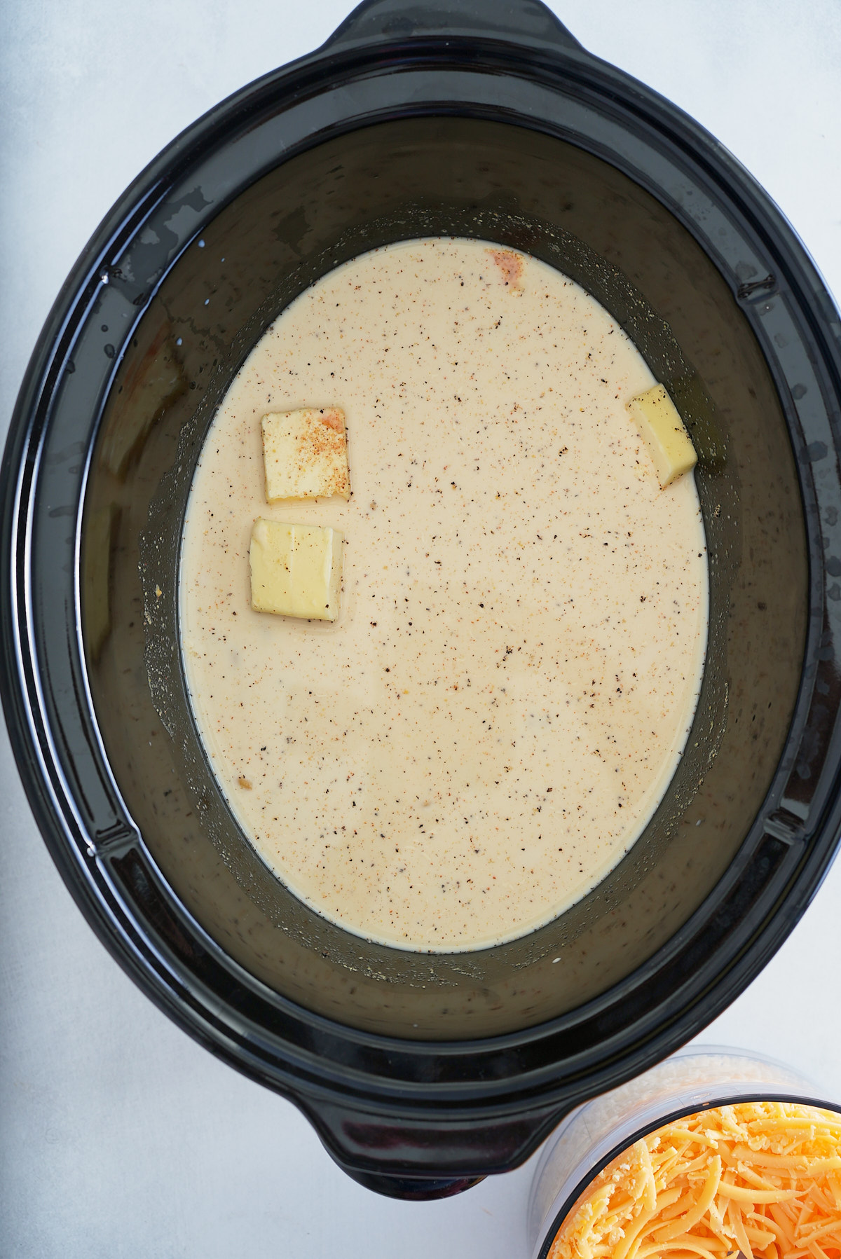 liquids in slow cooker with cheese on side