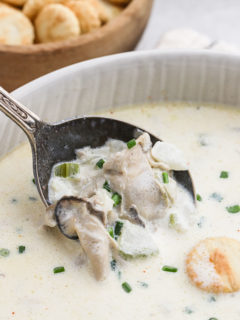 A spoon of oysters in oyster stew being removed