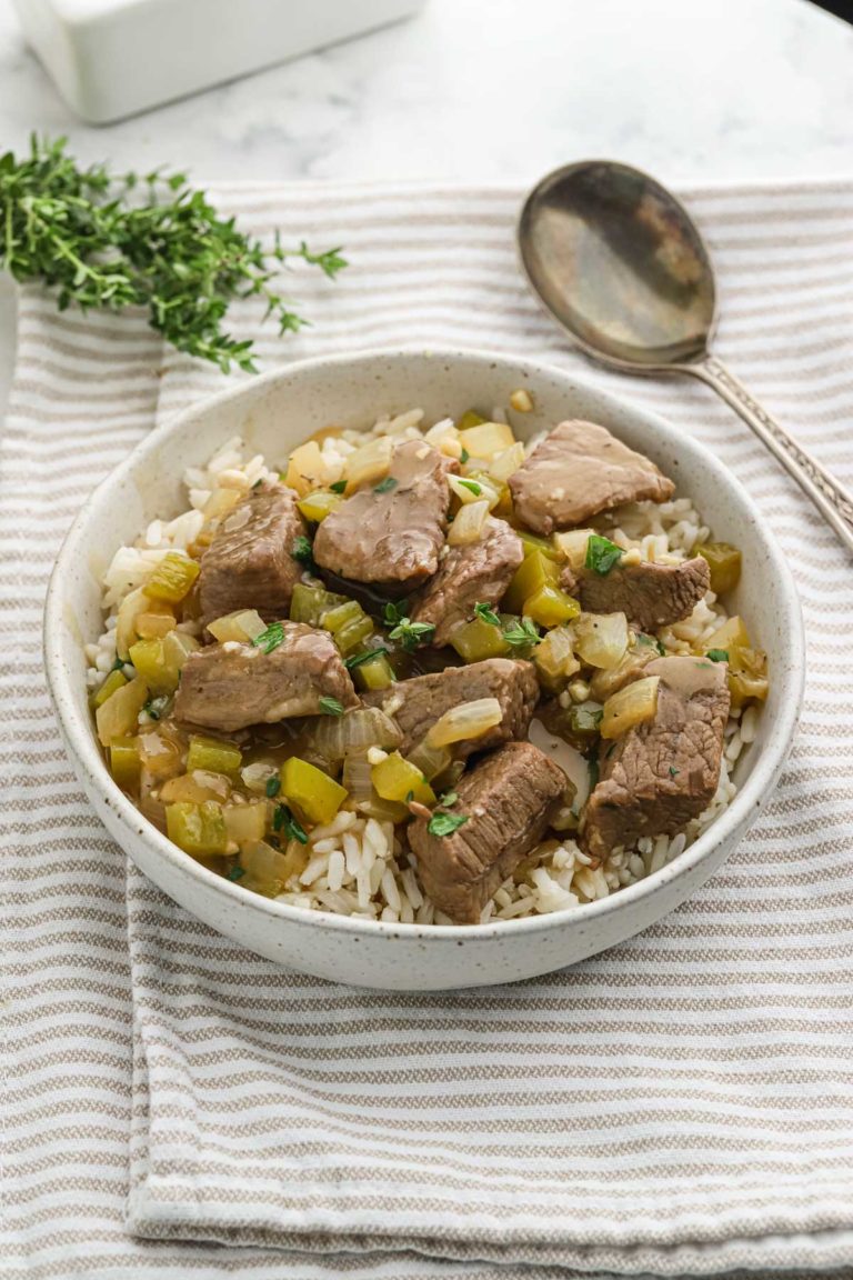 A large white bowl of rice and gravy ready to serve