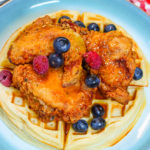 Fried Chicken and Waffles topped with syrup and fruit for a decadent brunch or dinner