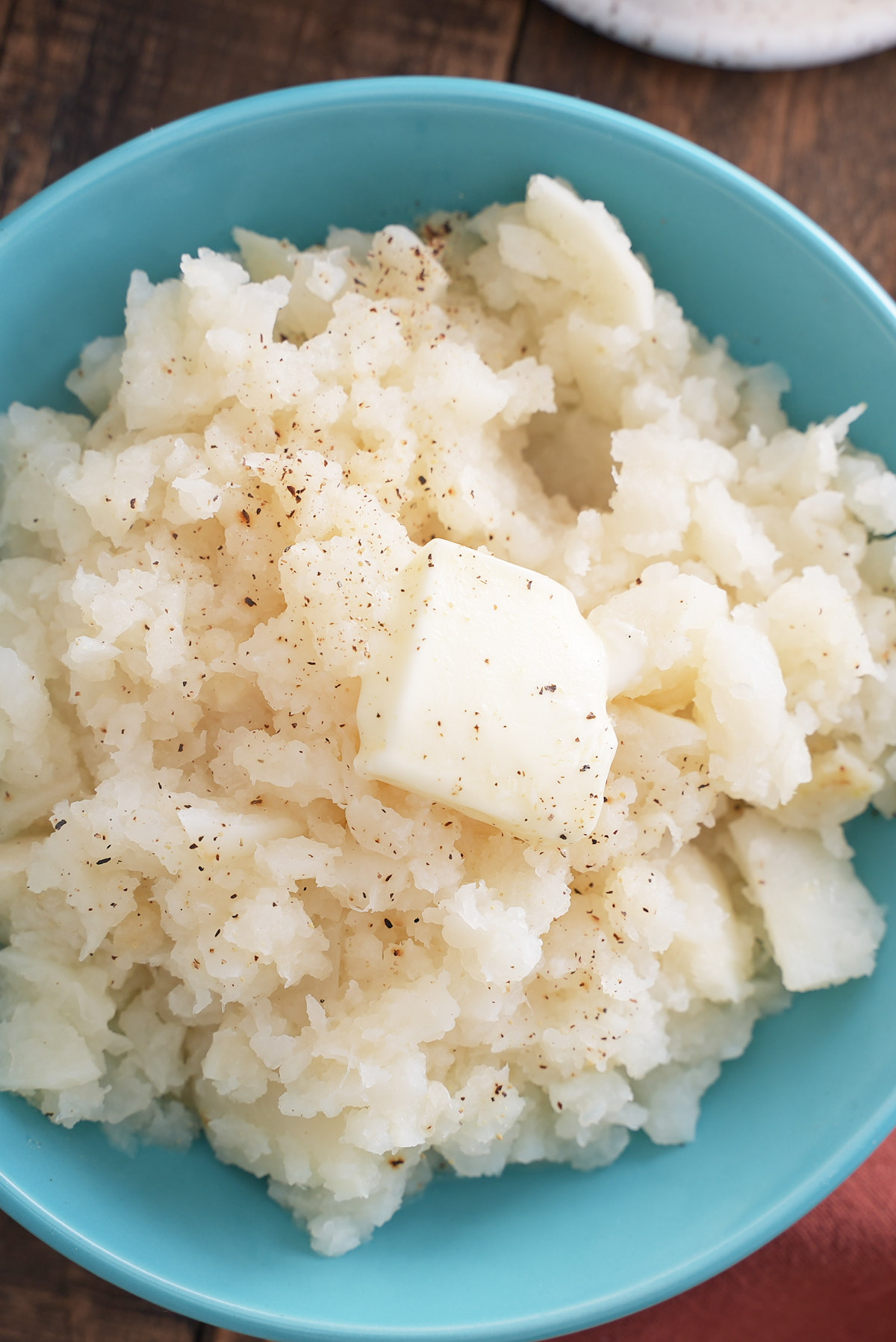 mashed turnips in bowl with butter on top