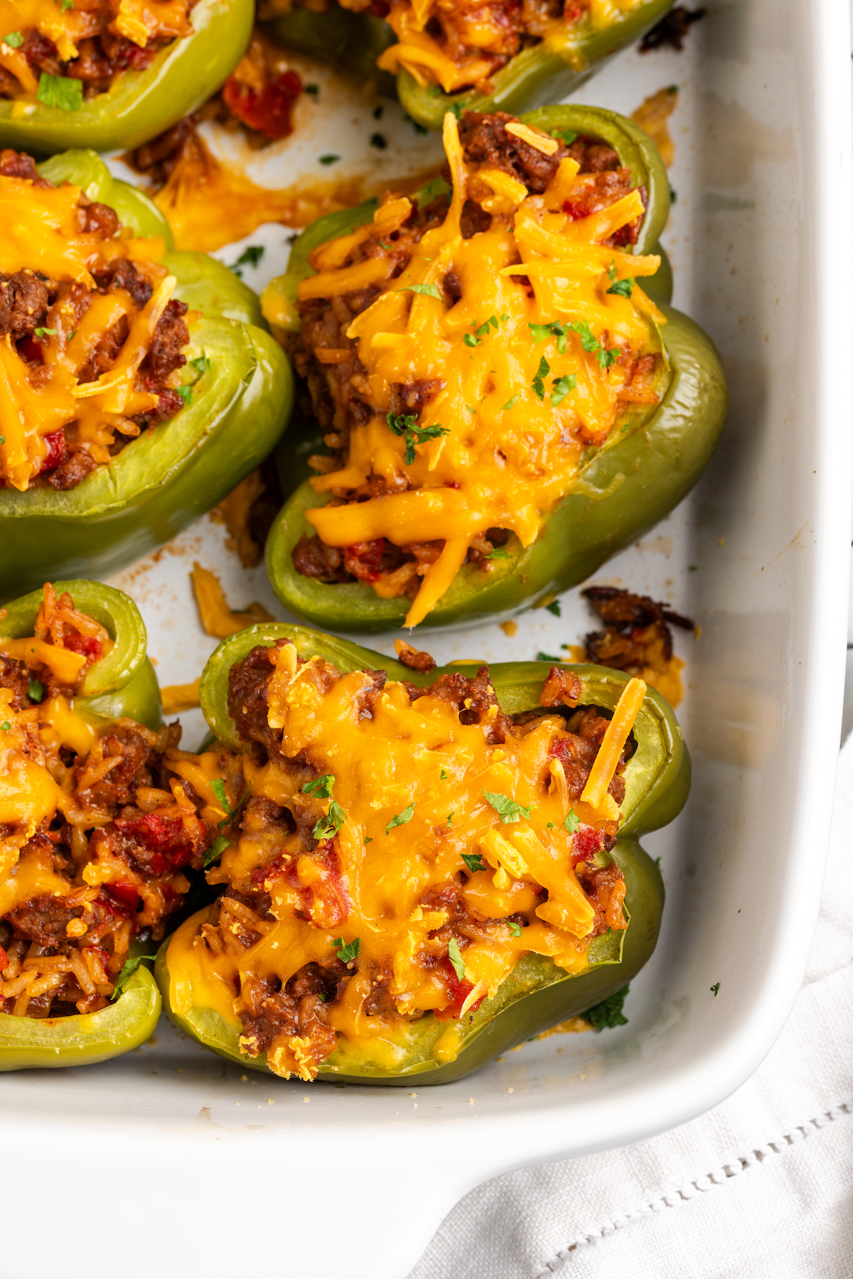 Overhead view of stuffed green peppers in baking dish