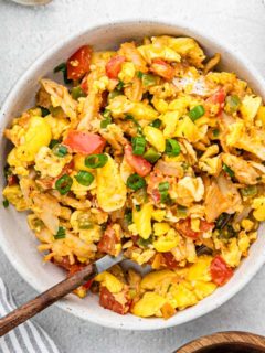 A white bowl with saltfish and ackee being served