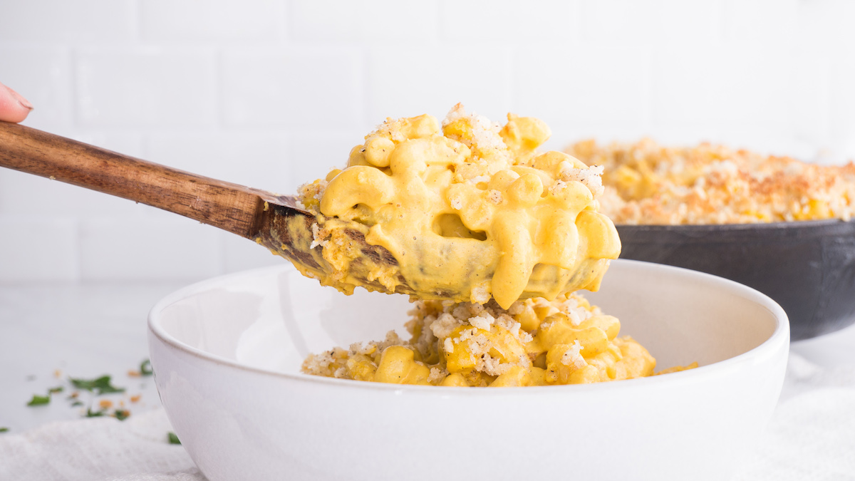 Spooning creamy vegan mac and cheese into bowl