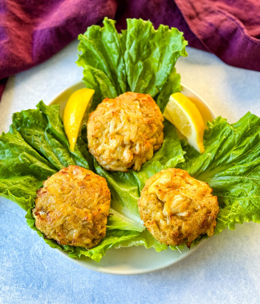 Maryland crab cakes on a bed of lettuce with fresh lemon