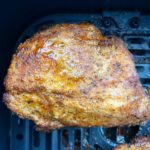 close up shot of cooked air fried pork chop in a black air fryer