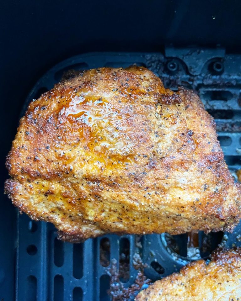 close up shot of cooked air fried pork chop in a black air fryer