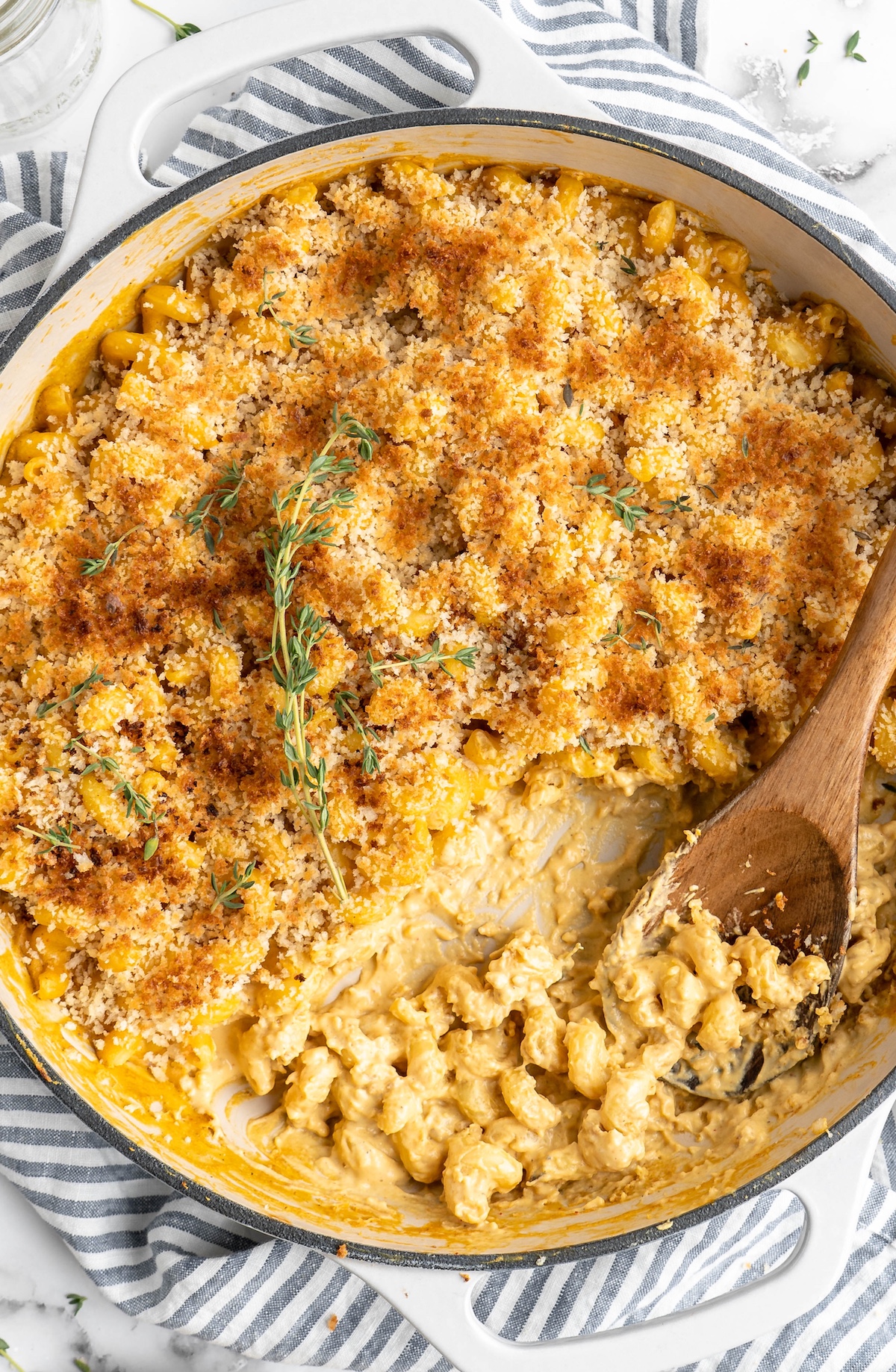 Overhead view of baked vegan mac and cheese in skillet with wooden spoon