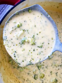 close up shot of broccoli cheese soup with a spoonful scooped out