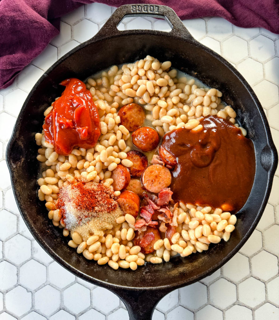 uncooked pork and beans in a cast iron skillet