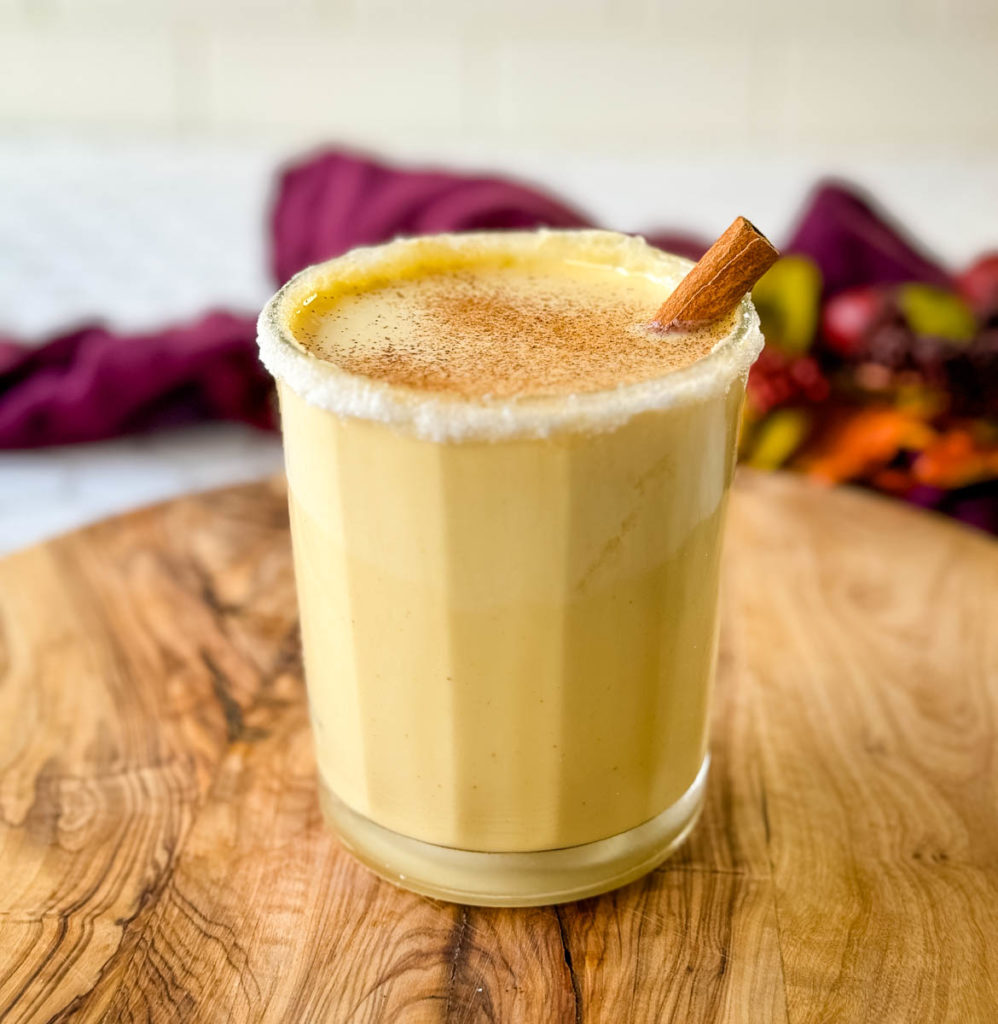 spiked eggnog in a glass with cinnamon