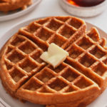 sweet potato waffles on white plate with syrup in background