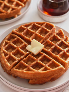 sweet potato waffles on white plate with syrup in background