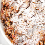 Vegan bread pudding in baking dish dusted with powdered sugar