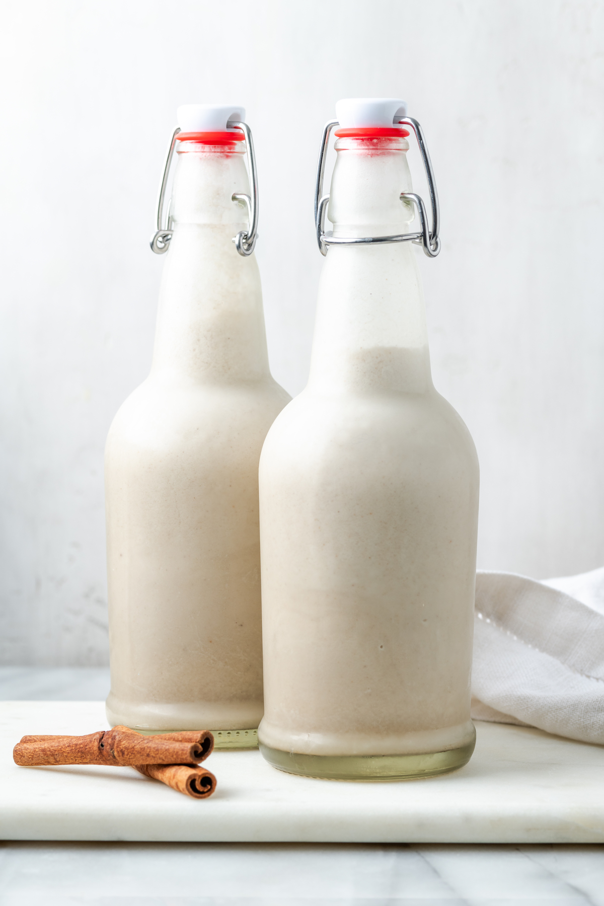 Two glass bottles of vegan coquito