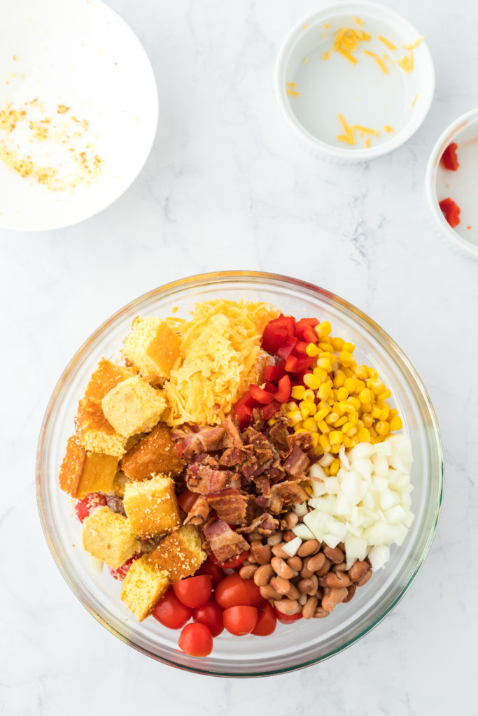 Cornbread, bacon, corn and other ingredients in a bowl to toss together