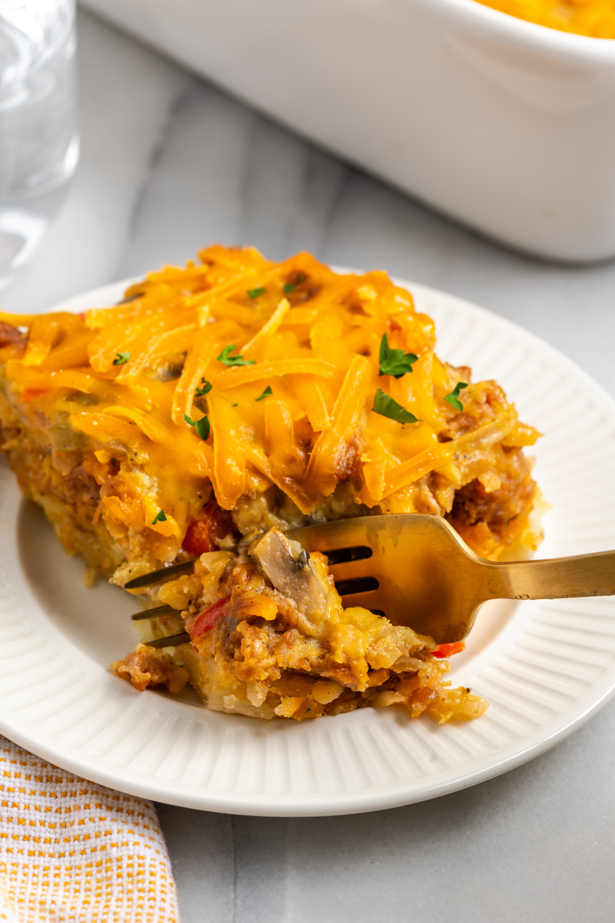 Vegan hashbrown breakfast casserole on plate with fork