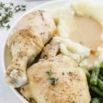 chicken and gravy plated with mashed potatoes and green beans.