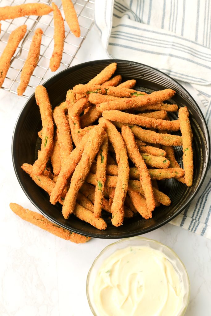 A plateful of Crispy Fried Green Beans ready to dip into fresh remoulade sauce
