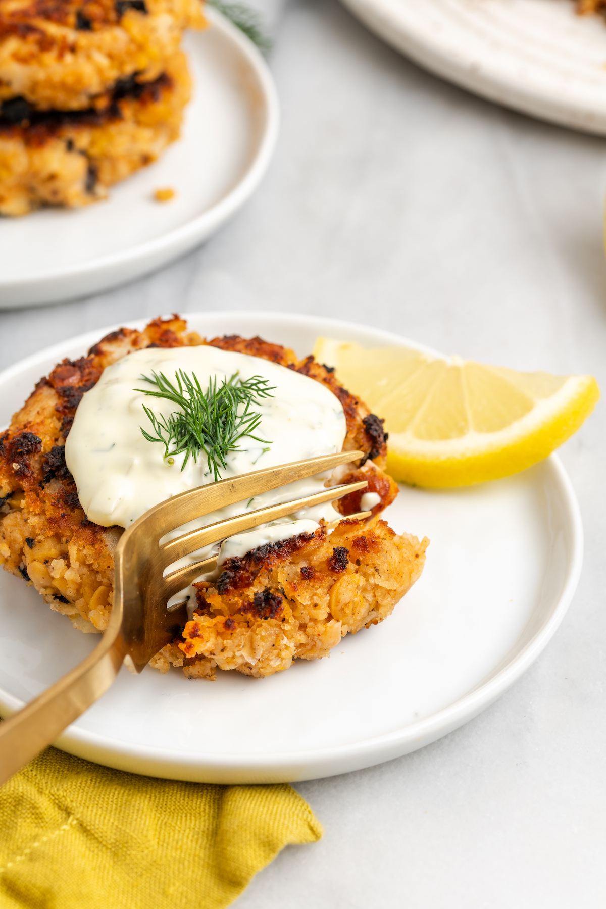 Vegan crab cake on plate with fork cutting into it