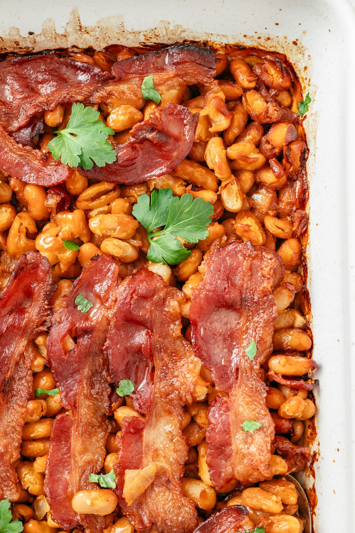 Baked beans in a baking dish, featuring a delightful blend of canned beans cooked to perfection in a flavorful sauce.