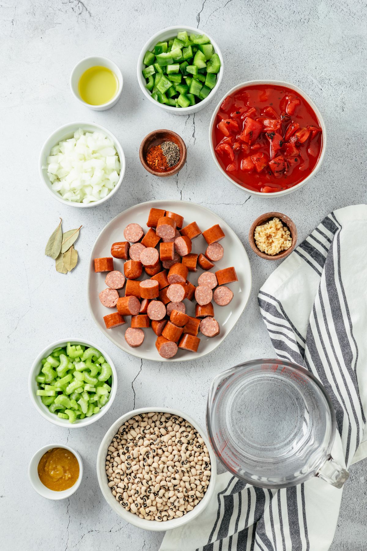 Ingredients for flavorful Black Eyed Peas Soup: Avocado oil, kielbasa sausage, yellow onions, green bell pepper, celery, minced fresh garlic, fire-roasted tomatoes, dried black-eyed peas, water, Better than chicken bouillon, bay leaves, black pepper, and homemade Cajun seasoning.