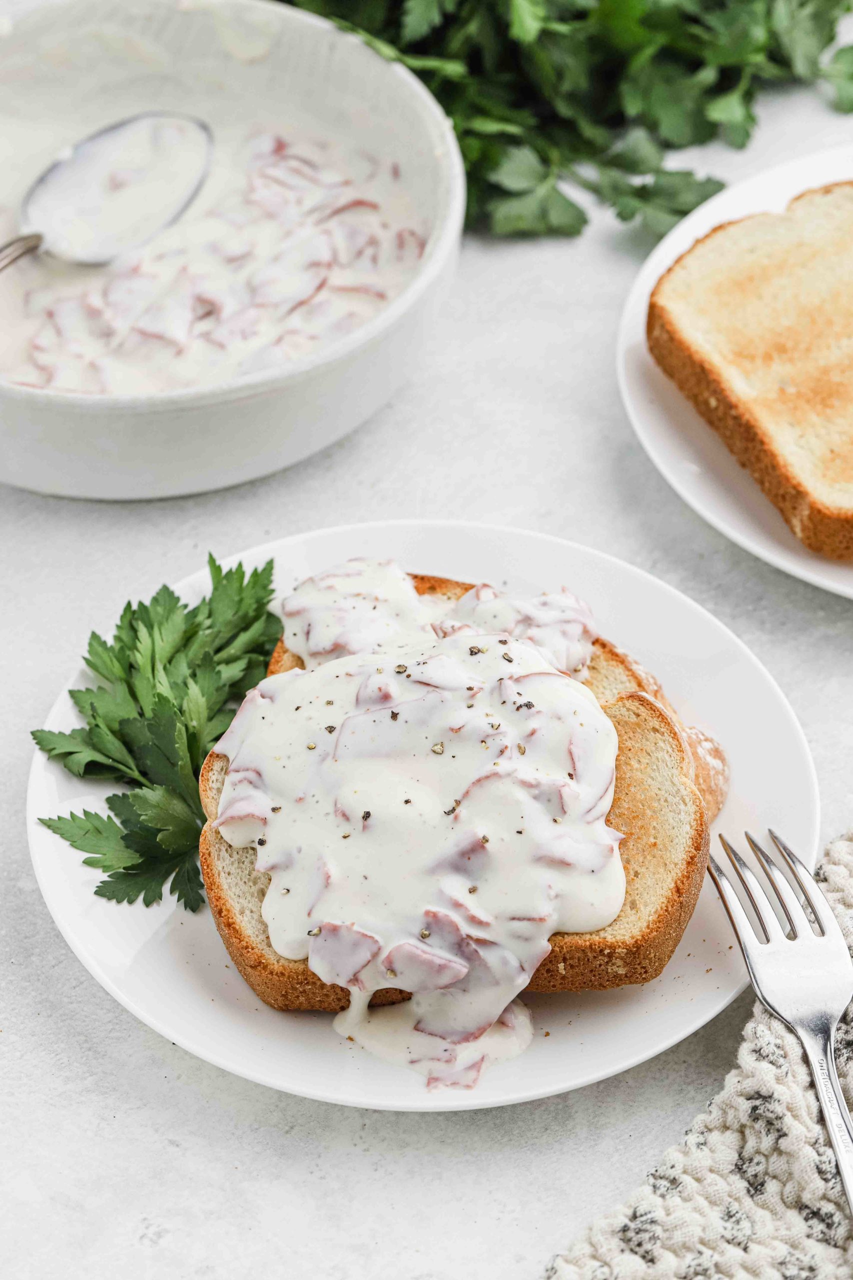 two slices of toast with chipped beef gravy on top.