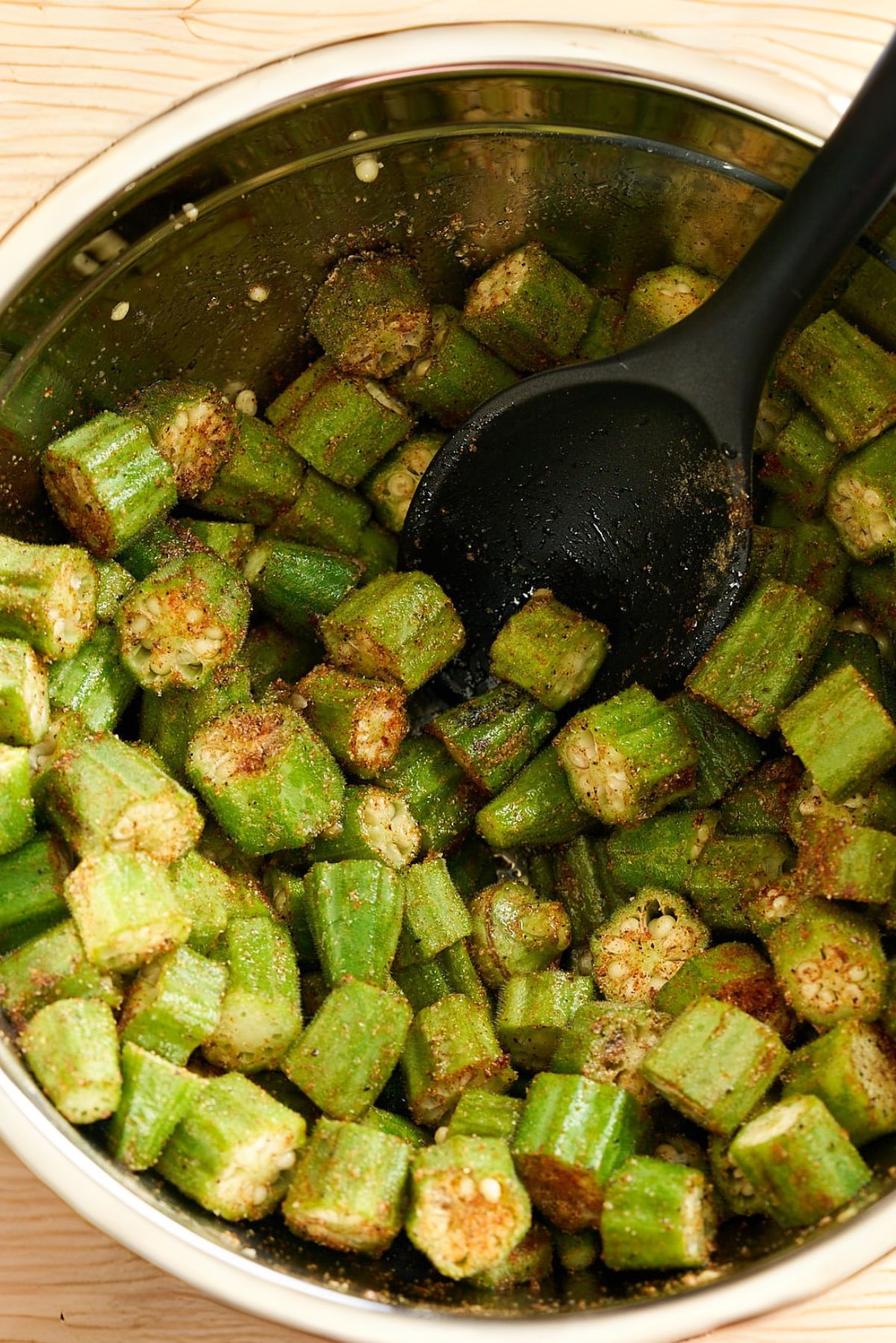 cut okra in bowl tossed in oil and seasoning