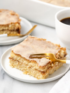 Serving of honeybun cake on plate with fork cutting into corner