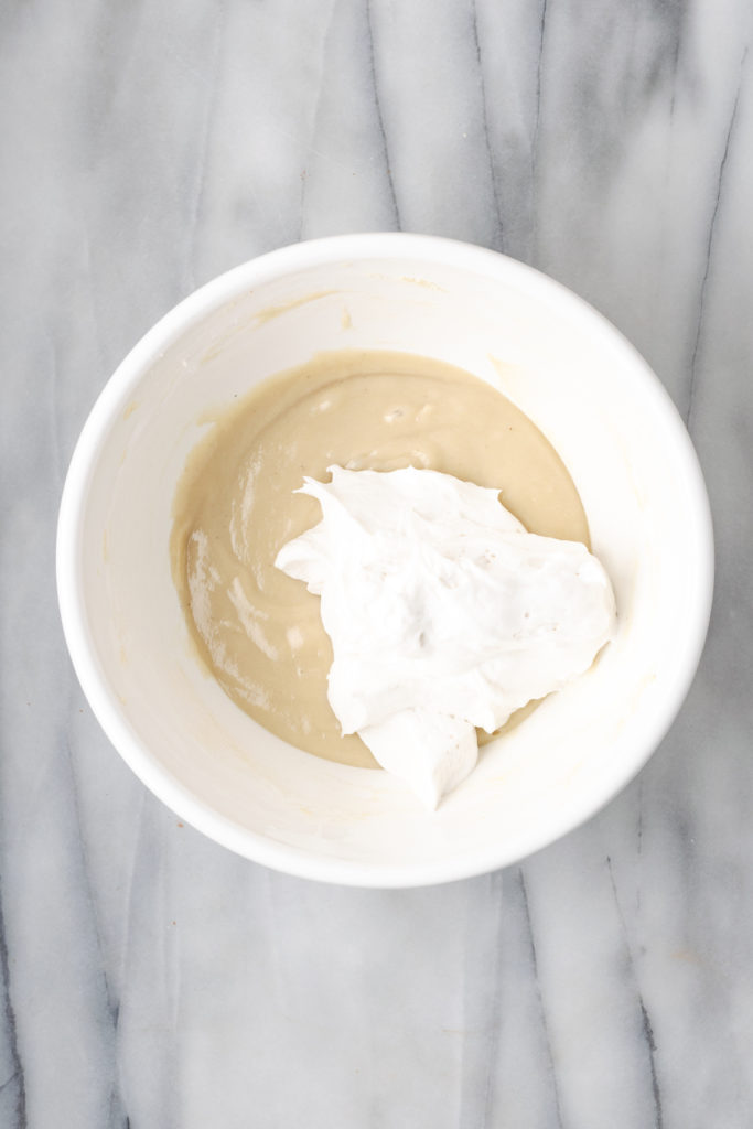 Overhead view of whipped cream added to cream cheese mixture