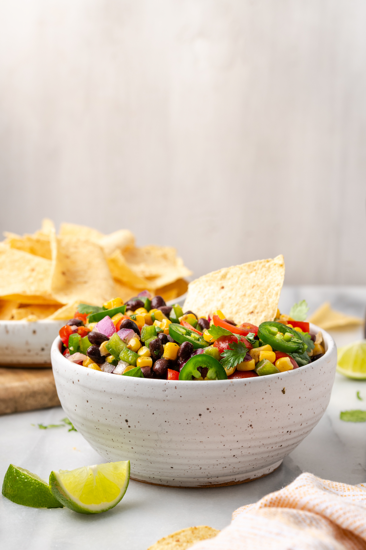 Bowl of fresh corn salsa with tortilla chip in it