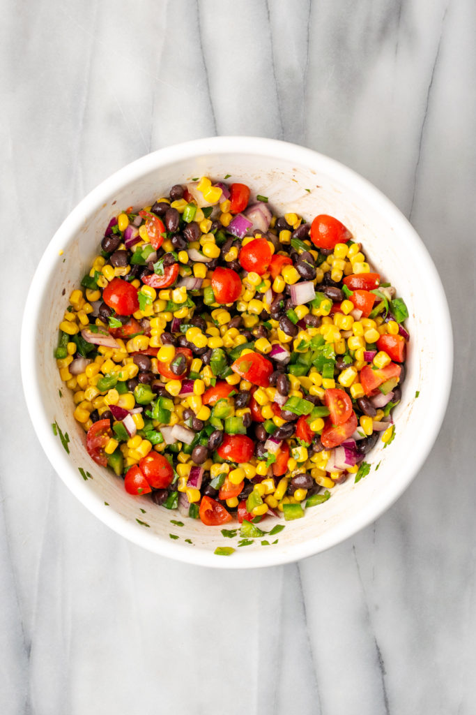 Overhead view of corn salsa in mixing bowl