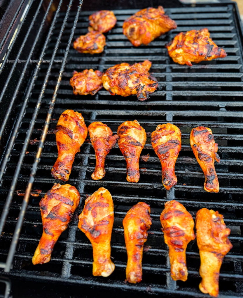 chicken drumsticks and chicken thighs on a grill