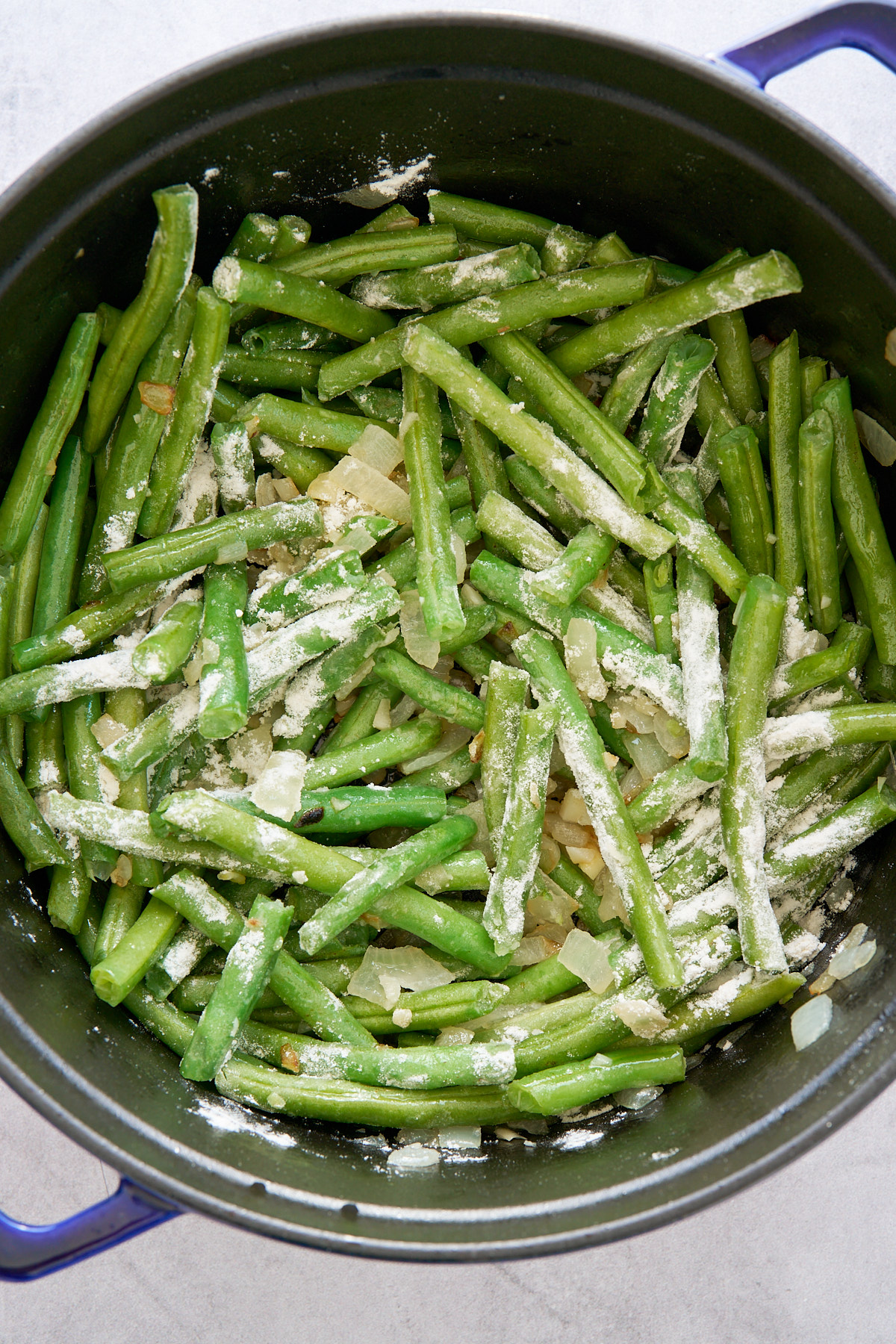 green beans covered with flour in pot while being cooked