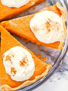Slicing up a cooled sweet potato pie and adding a dollop of homemade whipped cream