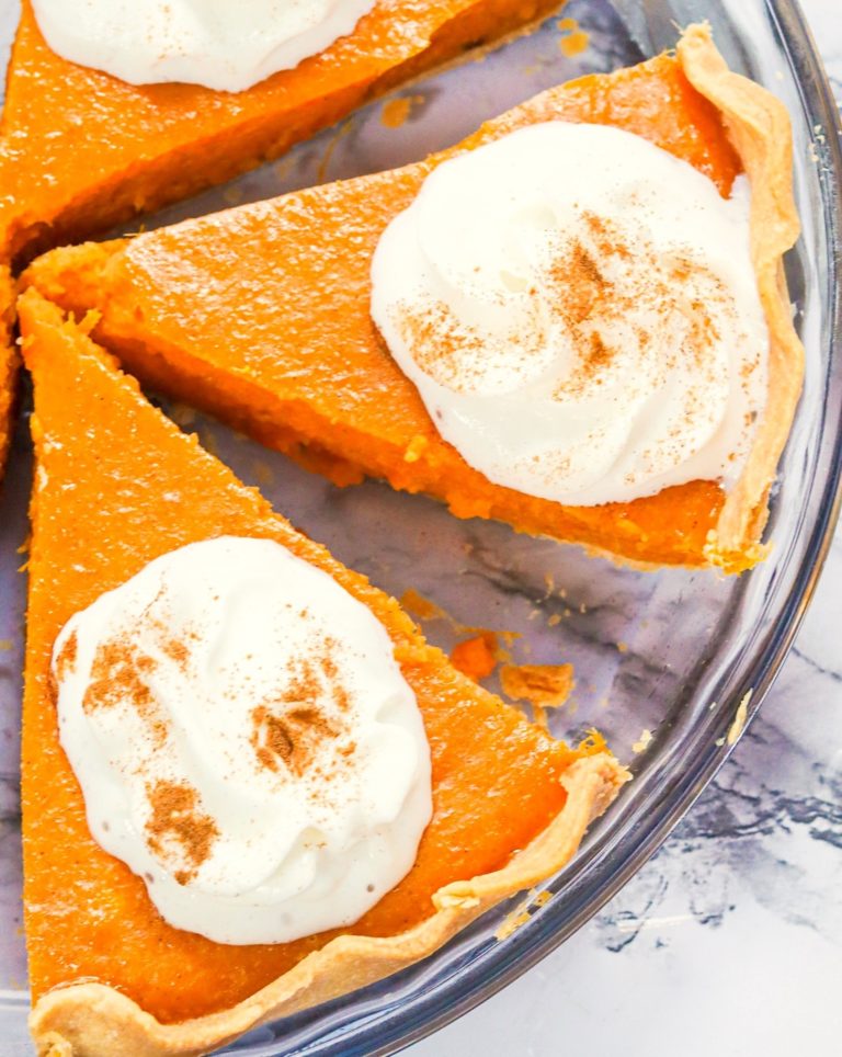 Slicing up a cooled sweet potato pie and adding a dollop of homemade whipped cream