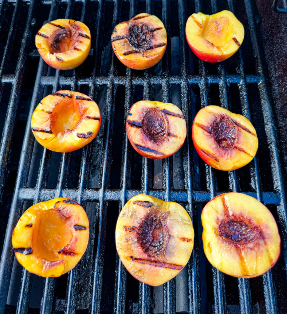 peaches sliced in half on a grill