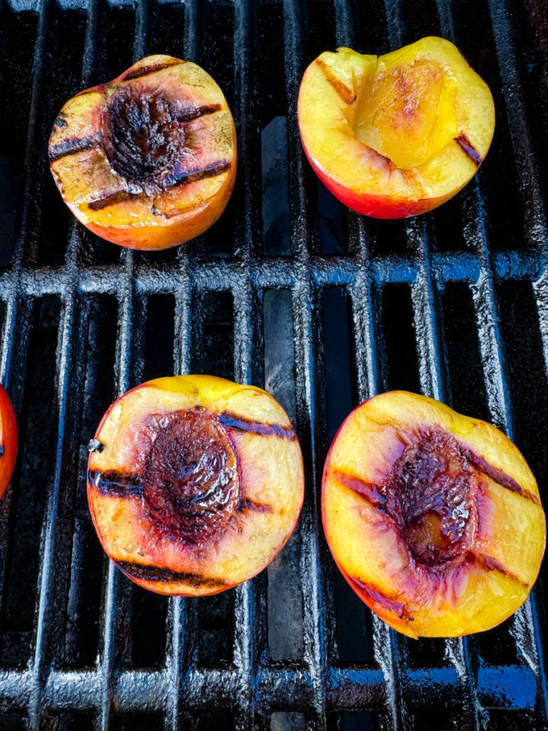 peaches sliced in half on a grill