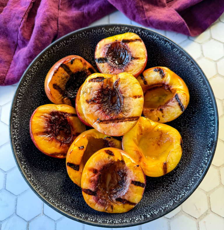 grilled peaches in a black bowl