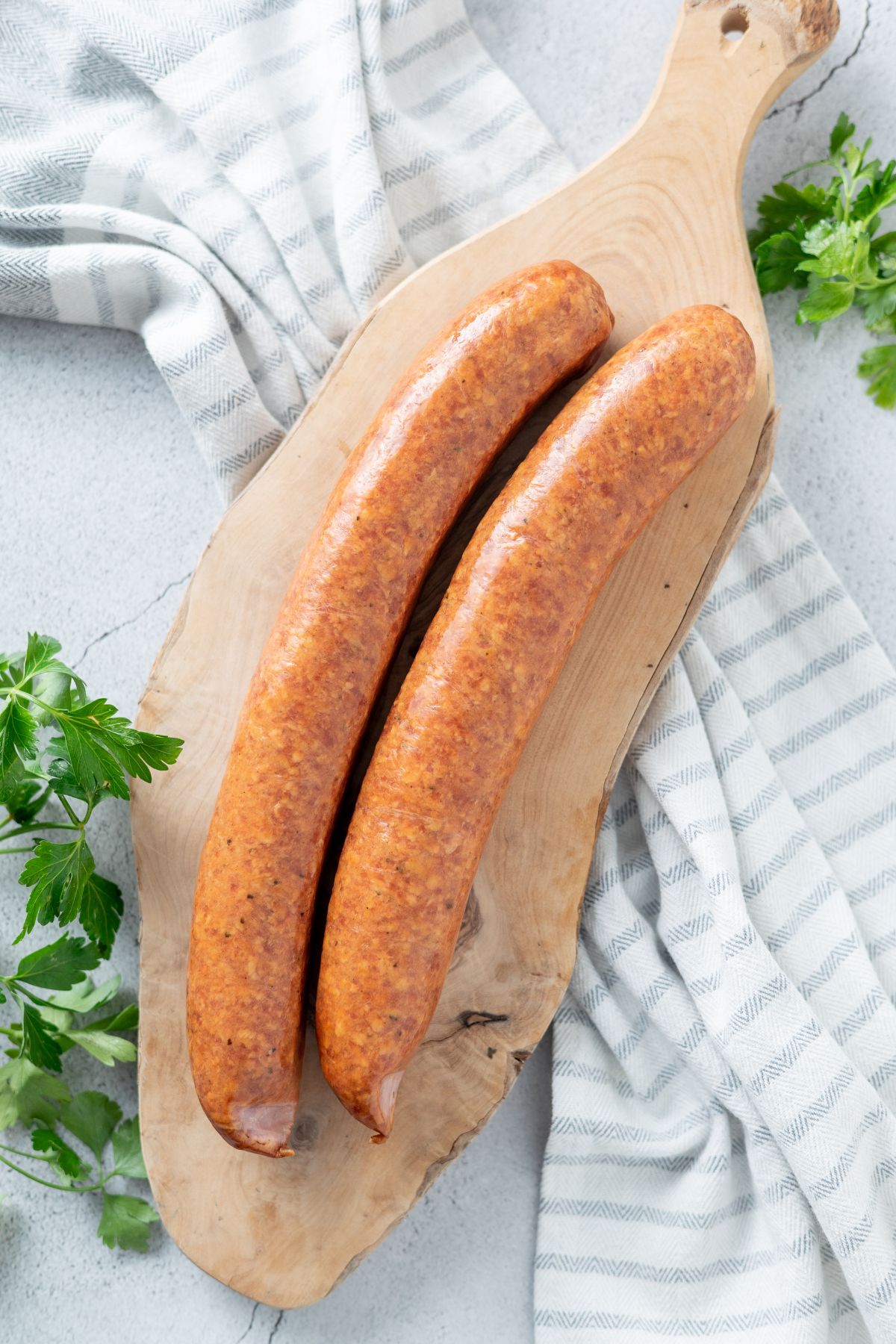 2 smoked sausages on a wooden board