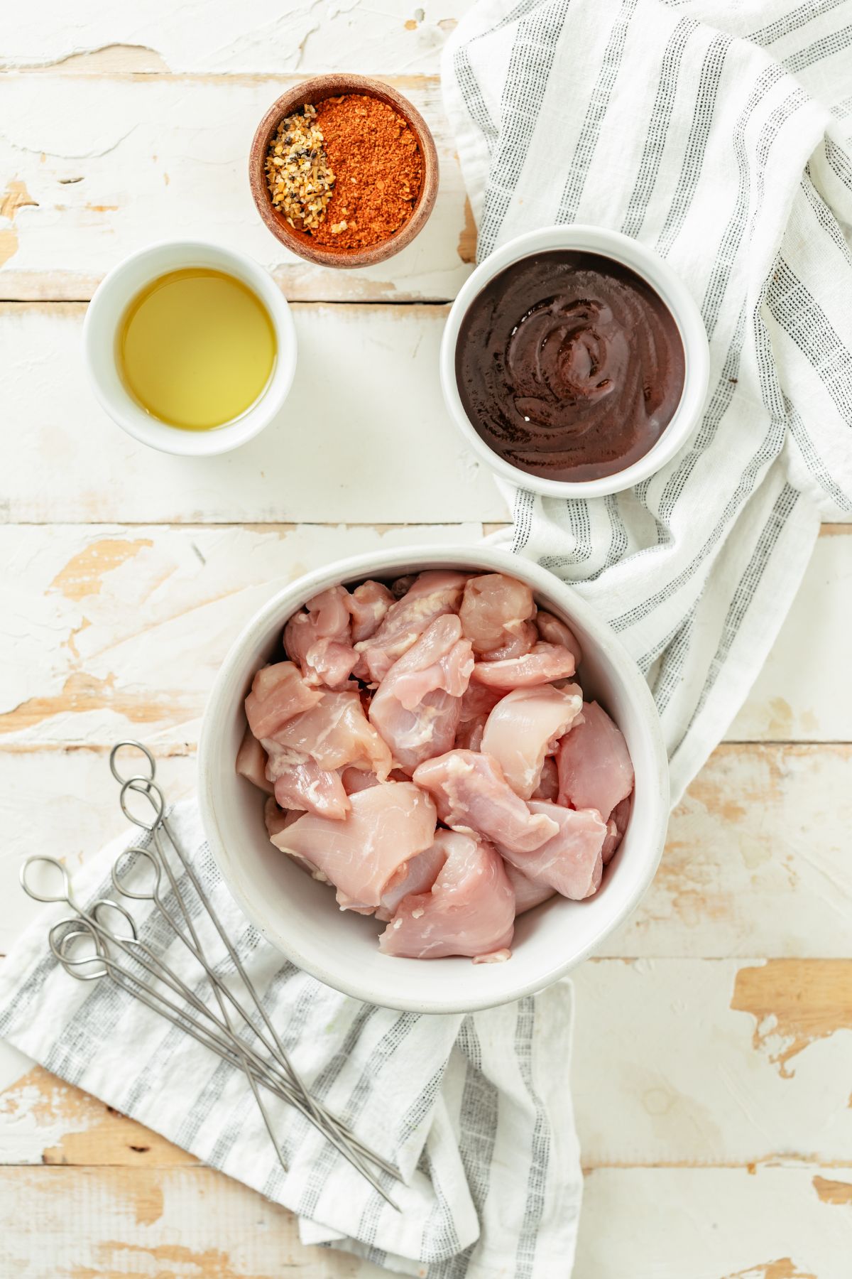Ingredients for chicken skewers: diced chicken thighs, steak seasoning, BBQ dry rub, avocado oil, bourbon BBQ sauce