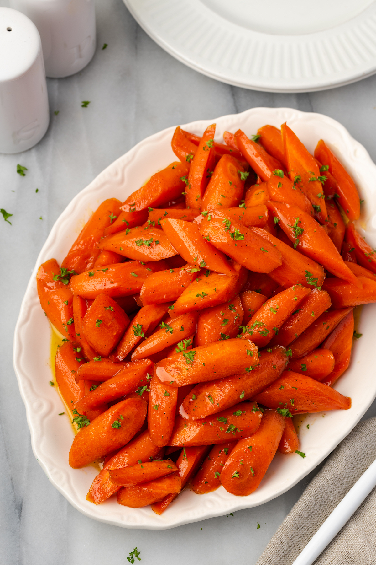 Overhead view of brown sugar glazed carrots on white platter