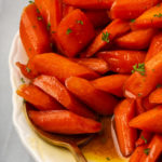 Vegan brown sugar glazed carrots on platter with serving spoon