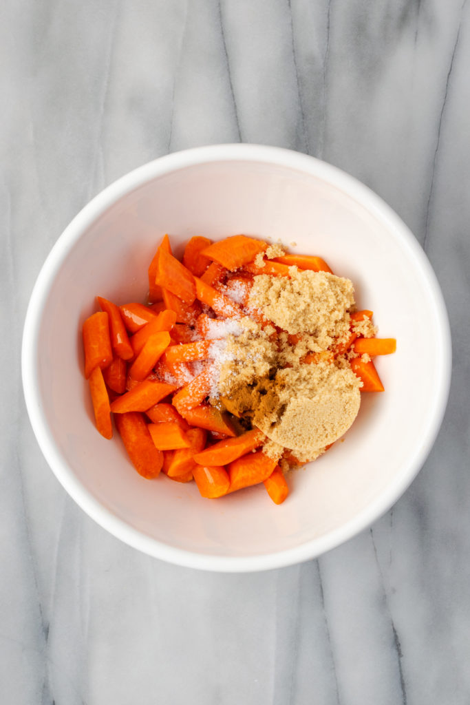 Overhead view of ingredients for brown sugar glazed carrots in mixing bowl