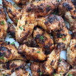 close up shot of grilled chicken wings on a white plate