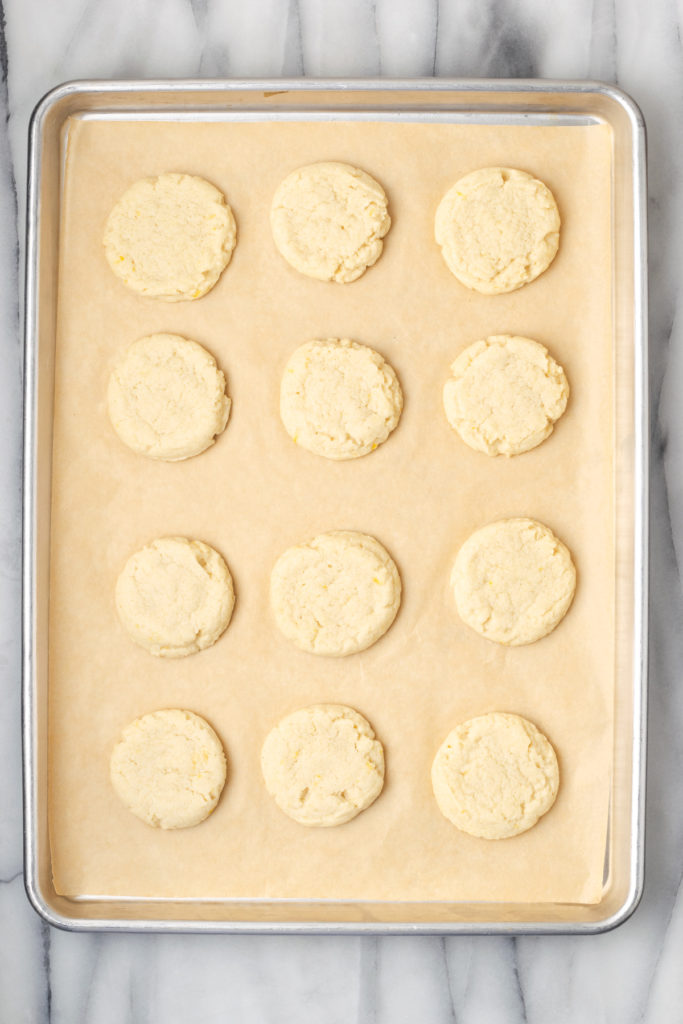 Overhead view of baked lemon cookies on parchment lined pan