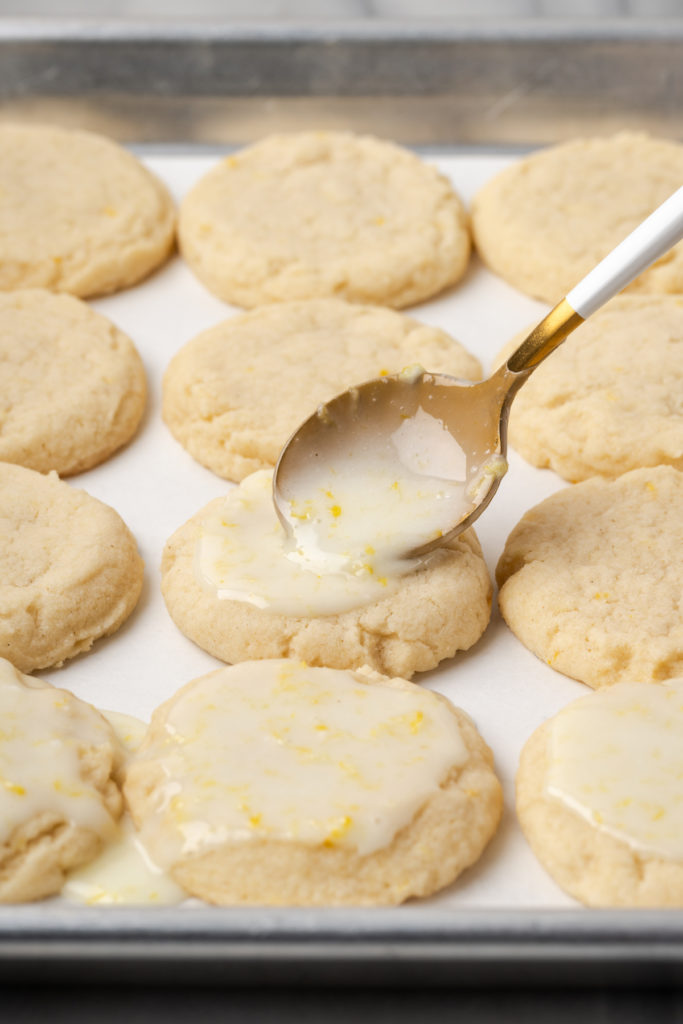 Spooning icing onto lemon cookies