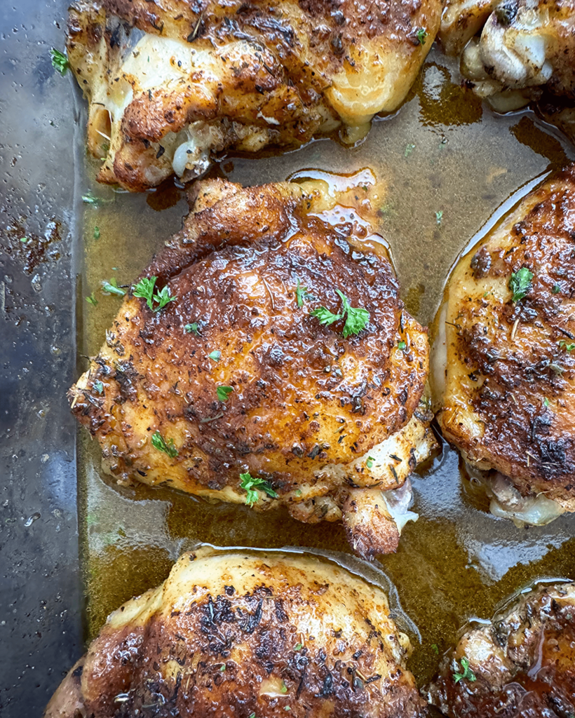 close up shot of naked chicken thighs in a glass baking dish